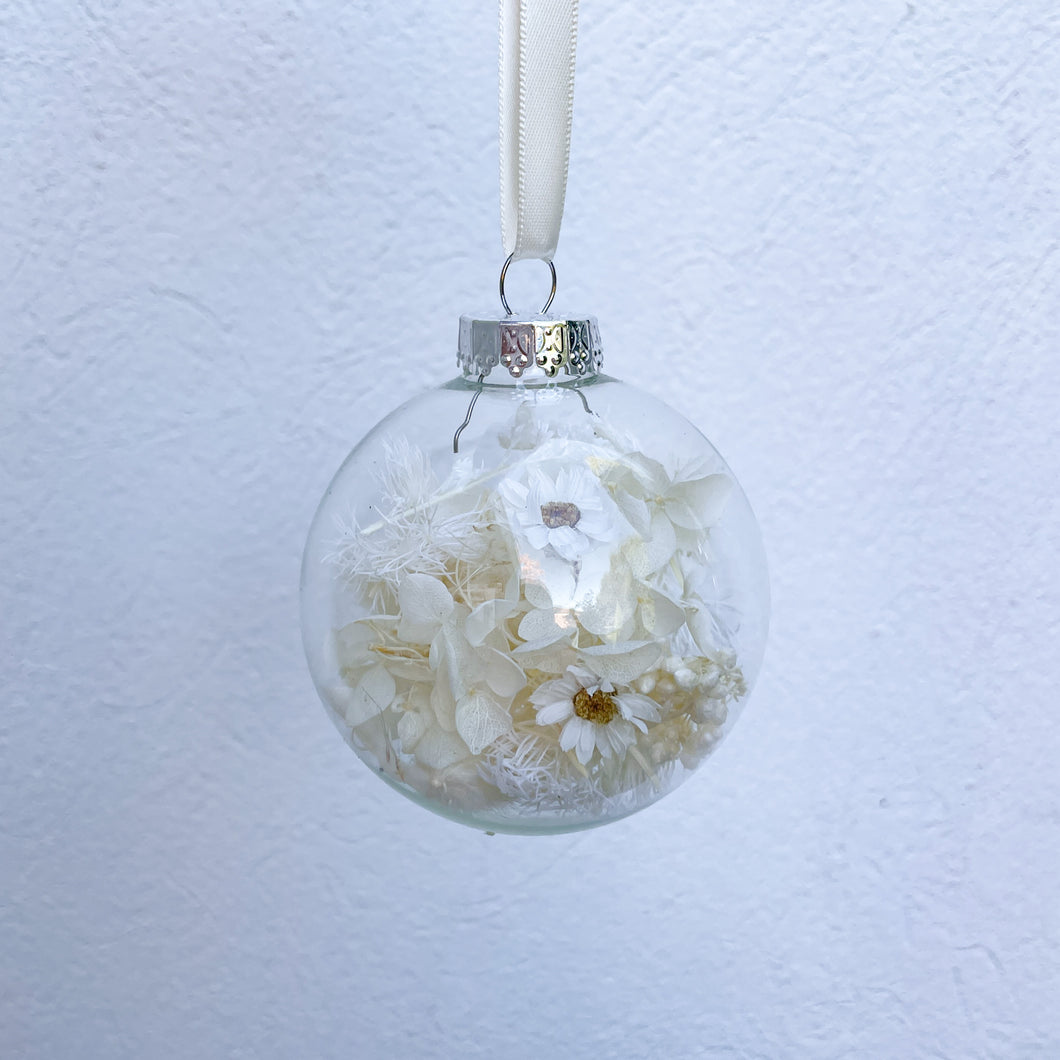 Individually packaged clear glass Christmas bauble filled with white and cream preserved flowers. Unique Christmas tree decoration created by Melbourne florist Joyful Blooms. Perfect gift option for teacher gifts, stocking fillers, Christmas table settings.