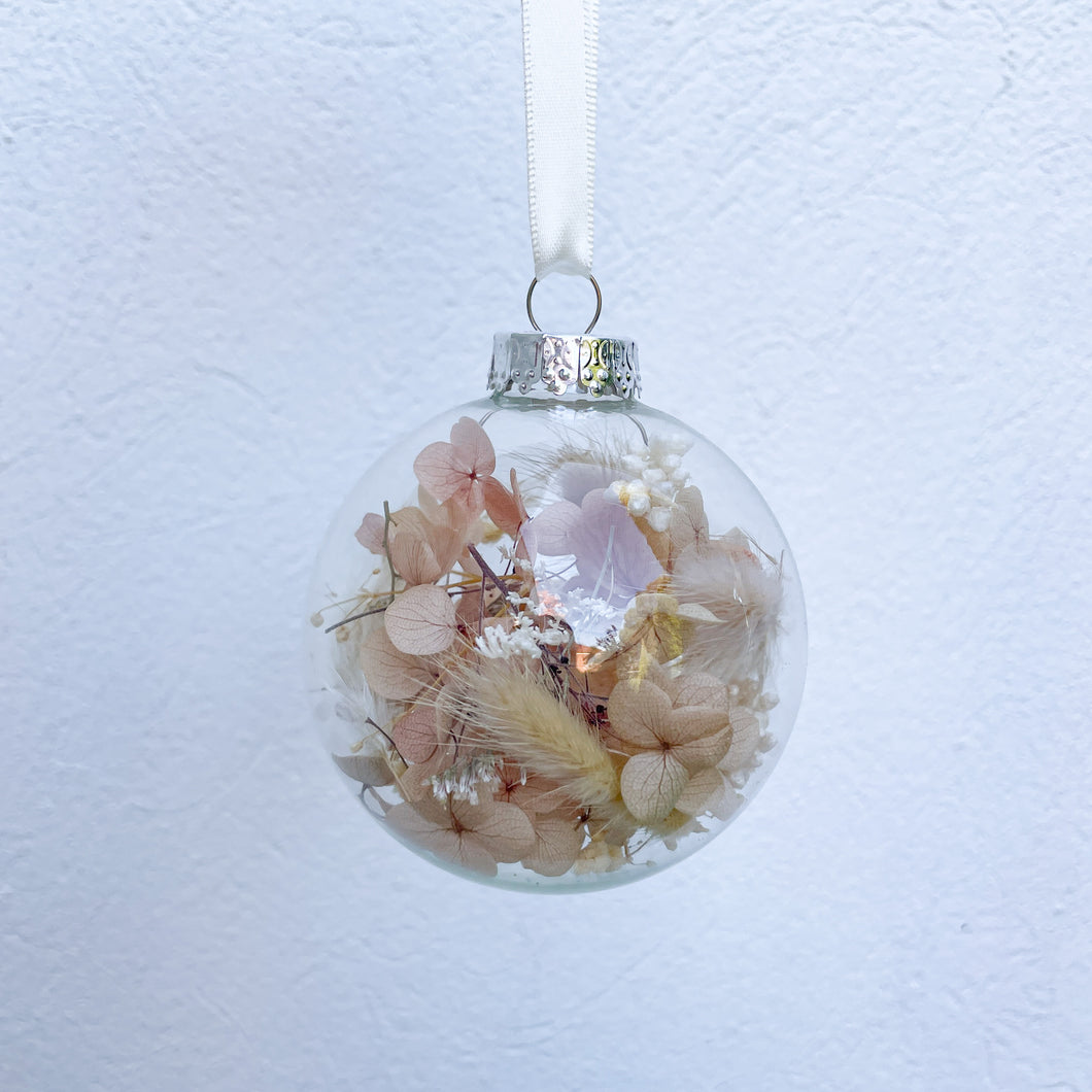 Individually packaged clear glass Christmas bauble filled with nude, natural and white preserved flowers. Unique Christmas tree decoration created by Melbourne florist Joyful Blooms. Perfect gift option for teacher gifts, stocking fillers, Christmas table settings.